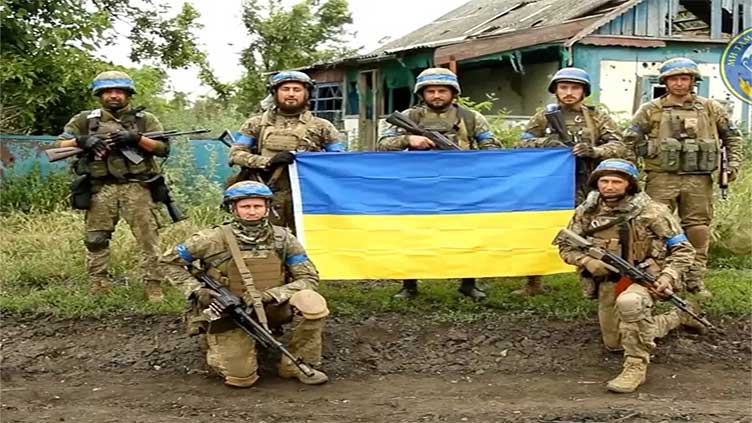 Украинский флаг над разрушенным зданием в Роботино